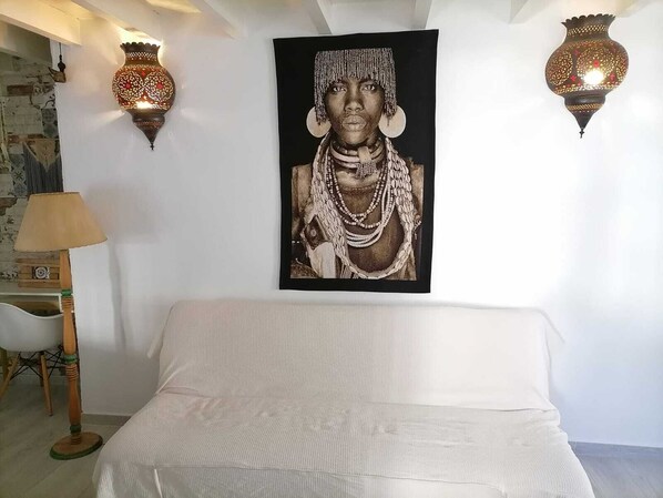 Un dormitorio con una cama, un cuadro colgado en la pared y dos apliques.