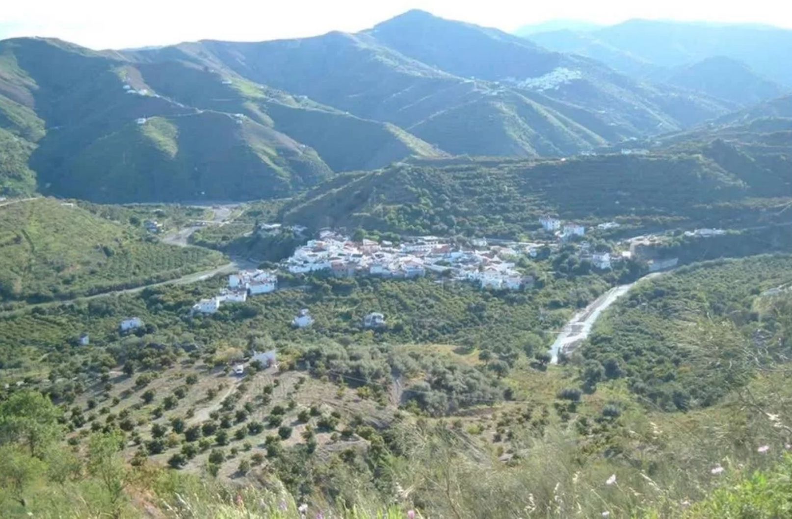 A mountainous landscape with a small village nestled in a valley.
