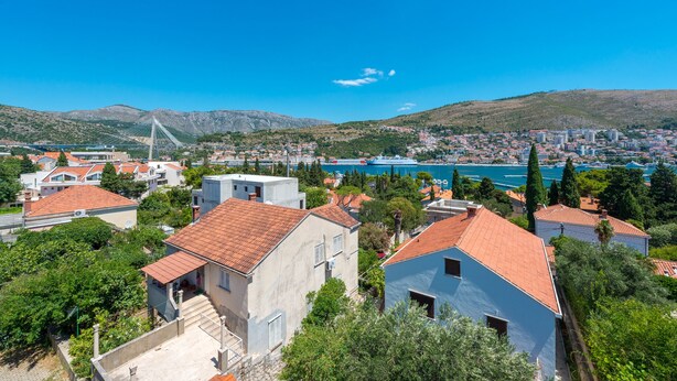 A coastal town with a prominent bridge, residential buildings, and a view of the sea. - Apartment Maro Bayview (Dubrovnik)