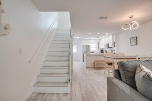 A modern interior with a staircase, a dining area, and a living space.