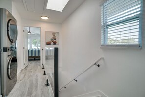 A laundry room with a washing machine, a drying rack, and a ceiling light. - Sunset Landings 5 (Bradenton Beach)