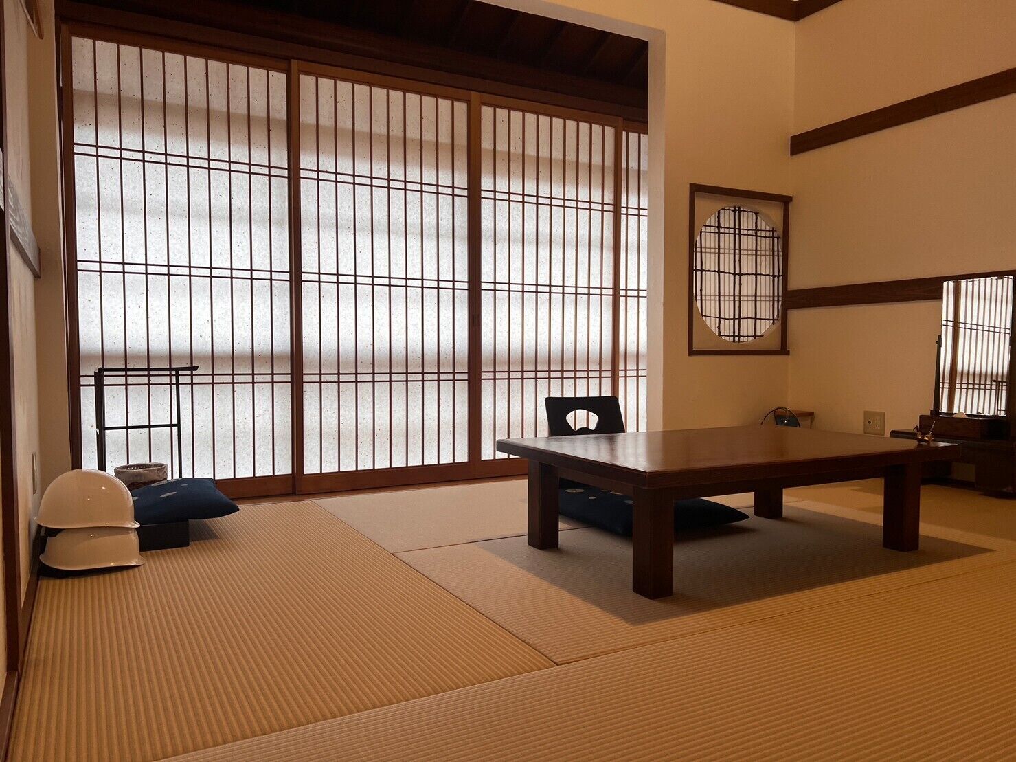 A traditional Japanese room with tatami flooring, a low table, and sliding doors.