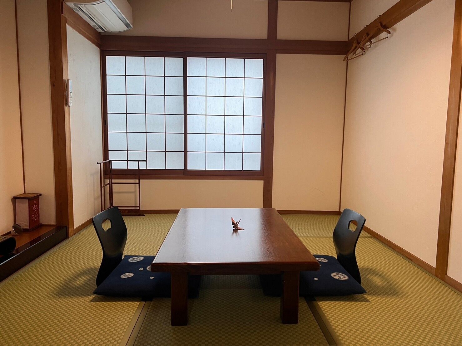 A traditional Japanese room with tatami flooring, a low table, and shoji screens.