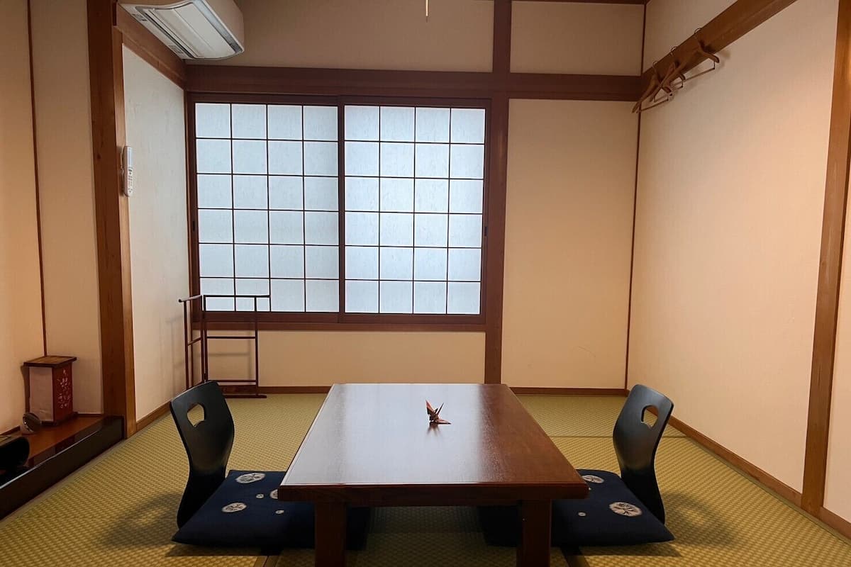 A traditional Japanese room with tatami flooring, a low table, and shoji screens.