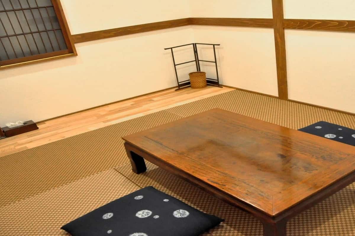 A tatami mat room with a wooden table and cushions.