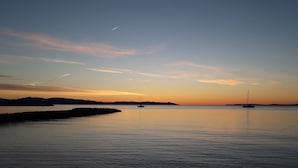 Una masa de agua tranquila con barcos y cielo despejado.