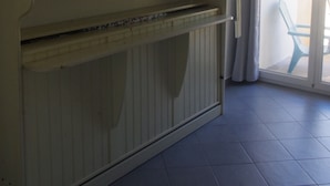 Una habitación con un armario grande, un ventanal corredero que da a un espacio exterior y piso de baldosas.