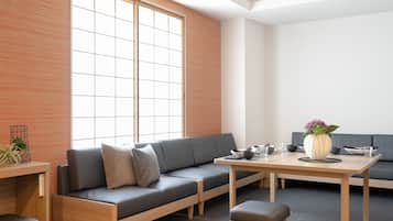 Un interior moderno con un sofá, una mesa de comedor y un ventanal grande.