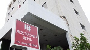 A building with a sign indicating a hotel named 'River View Hotel' with a contact number. - Kawanoe Business Hotel (Shikokuchuo)