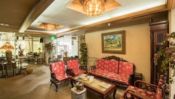 Un interior tradicional con muebles de madera, un candelabro y una pintura en la pared.