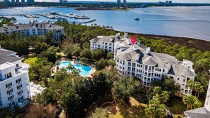 Een resort met meerdere gebouwen, een zwembad en een jachthaven met boten.