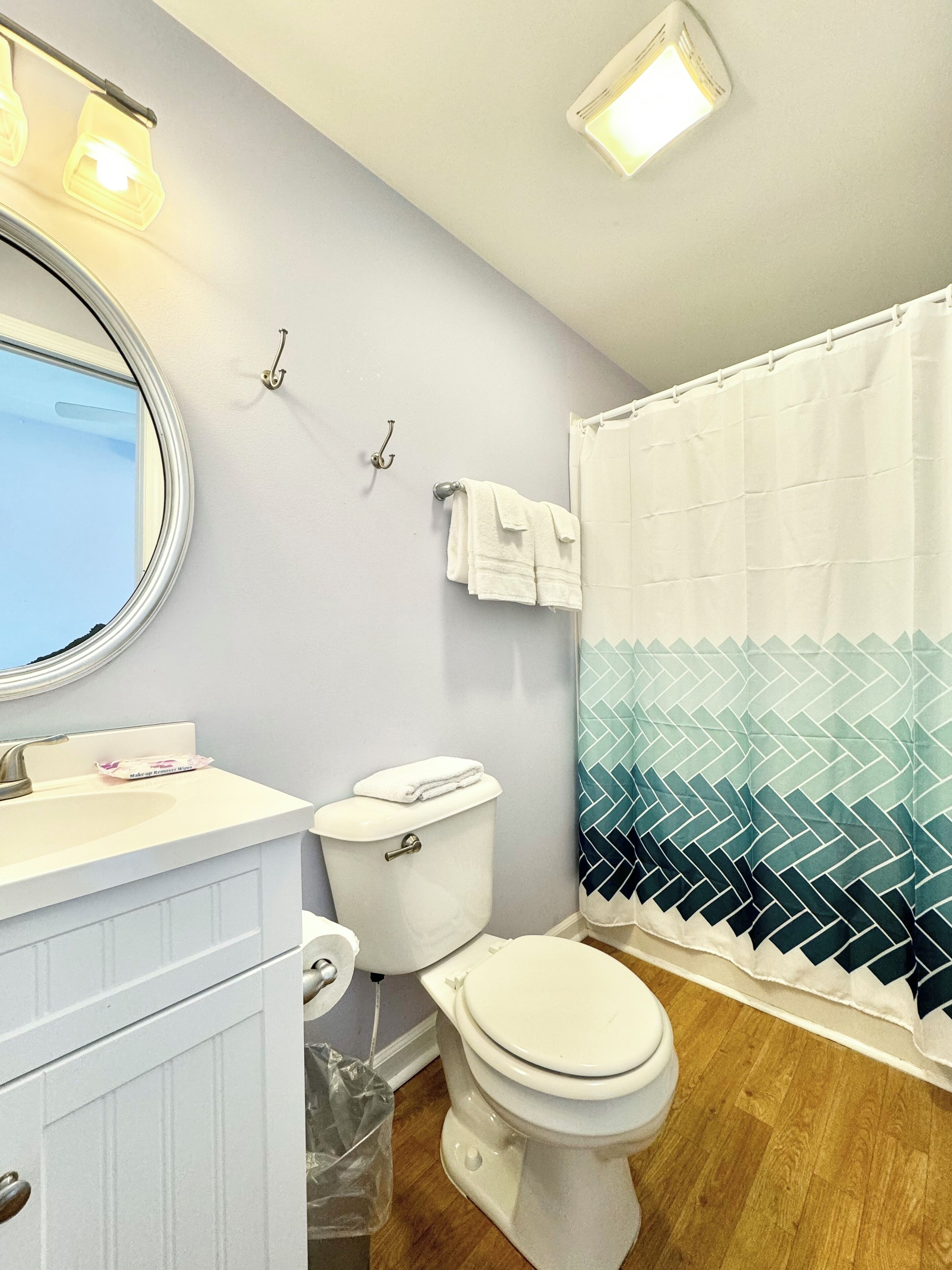 Un baño con inodoro, lavabo y cortina de ducha.