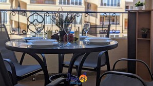 Une table ronde avec quatre chaises, un plateau en verre et un élément décoratif au centre.