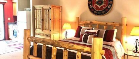 Ein Bett mit Holzkopf, ein Kleiderschrank, eine runde Wanddekoration und zwei Nachttischlampen.