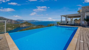An infinity pool with a clear view of the sea and mountains.