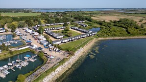 A marina with boats, a dock, and mobile homes along the water's edge. - 4 Avocet Quay , Emsworth  - sleeps 4 guests  in 2 bedrooms (Emsworth)