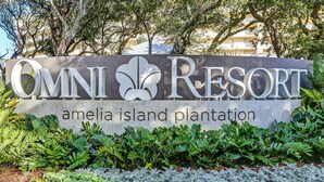 A sign for Omni Resort Amelia Island Plantation with a logo and name.