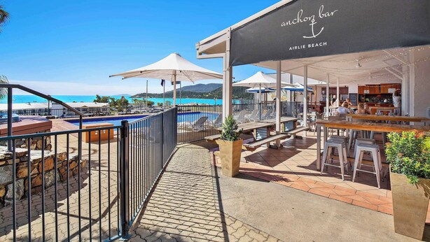 A beachside bar with outdoor seating and a pool view.