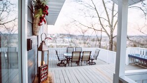 A wooden deck with outdoor furniture and a view of a cityscape. - Beautiful Branson Home! Perfect Downtown Location! (Branson)