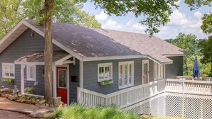 A two-story house with a grey exterior, a red door, and a white porch railing. - Beautiful Branson Home! Perfect Downtown Location! (Branson)