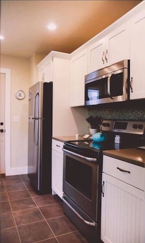 Enjoy cooking and food preparation in this well-equipped kitchen with a refrigerator, microwave, and oven.
