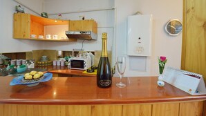 Een keukentafel met een champagnefles, een glas, een agenda en een bord met chocolade.