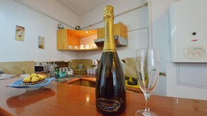 Een fles Cashionere champagne en een wijnglas op een houten aanrecht in een keuken.