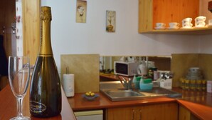 Een keuken met een houten aanrecht, een champagnefles en een glas.
