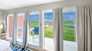 Une pièce dotée d’une grande porte-fenêtre coulissante donnant sur un espace extérieur avec vue sur la verdure et un escalier.