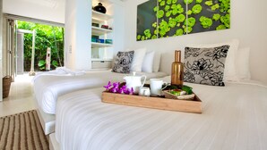 A modern bedroom with a large bed, a wooden tray with toiletries, and a view of lush greenery through an open door. - The Headland Villa 2, stunning beachfront, Samui (Koh Samui)