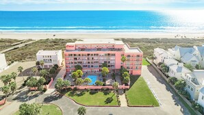 A multi-story hotel with a pool, located near a beach. - Beachfront Boutique Resort | Beachfront Bliss | Casa Condo 103 (Port Aransas)