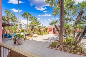A courtyard with palm trees, a pool, and a covered seating area.