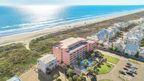 Un hotel frente al mar con piscina y varias construcciones.