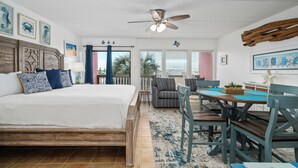 Ein Schlafzimmer mit einem großen Bett, einem Esstisch mit Stühlen und einem Deckenventilator.