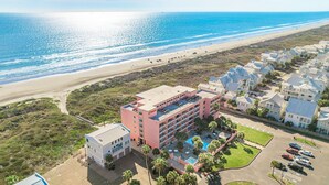 Ein Küstenhotel mit mehreren Gebäuden, einem Schwimmbad und Blick auf den Strand.
