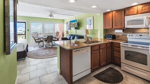 A compact kitchen with a dishwasher, stove, and microwave. - Beachfront Boutique Resort | Seaside Haven | Casa Condo 406 (Port Aransas)
