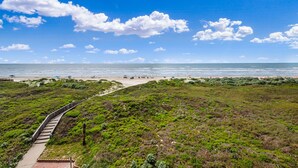 Un paisaje costero con un camino pavimentado que lleva a una playa.