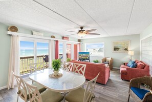 Relax in the living area with a round table, comfortable seating, and a stunning ocean view.