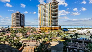 A resort with two high-rise buildings, a beach, and a tennis court.