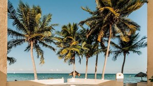 A pool area with palm trees and a view of the ocean. - Depa Bliss Cancún • Beachfront · King Beds · Pool · Luxury Stay • Best Host (Cancún)
