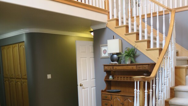 A spacious foyer with a wooden staircase, a large rug, and a wooden cabinet. - Alta/Snowbird Area Private Vacation Home, 9 miles to Resorts (Sandy)