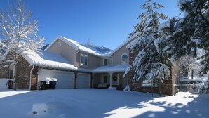 A two-story house with a garage, snow-covered roof, and a brick exterior. - Alta/Snowbird Area Private Vacation Home, 9 miles to Resorts (Sandy)