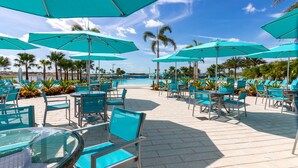 A resort pool area with turquoise umbrellas, lounge chairs, and a clear view of the pool. - Classic Margaritaville Cottage with Pool, Full Kitchen & Outdoor Living (Kissimmee)