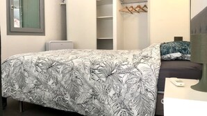 Ein Schlafzimmer mit einem Bett, einem Kleiderschrank und einem Nachttisch.