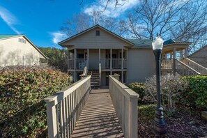 A two-story building with a covered porch and a wooden walkway leading to the entrance.
