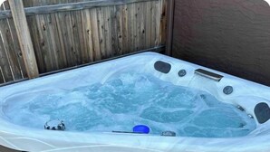 A hot tub with a built-in seat and a step for easy access.