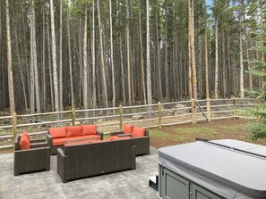Un espace patio aménagé avec des meubles en osier et un jacuzzi.
