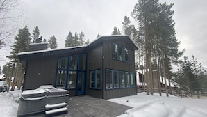 A modern two-story building with large windows and a covered patio area.