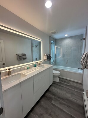 Tina con regadera, tina de hidromasaje, secadora de cabello, toallas 