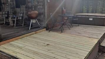 A wooden deck with a grill and outdoor furniture.